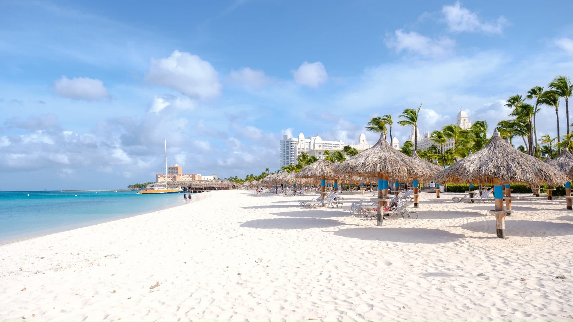 The white sand beach and palapas along the Palm Beach resort strip in Aruba