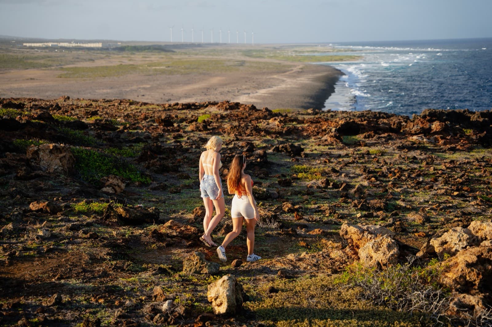 Couple on the rocky coast at golden hour