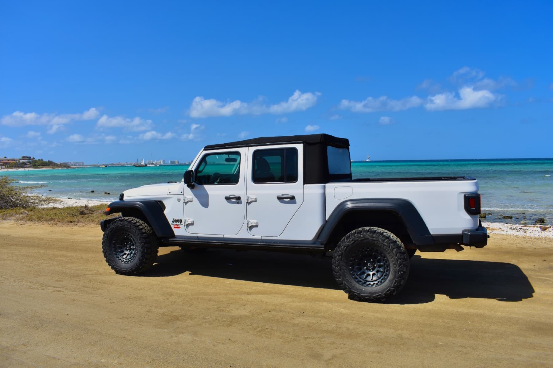 White Jeep Gladiator by the sea