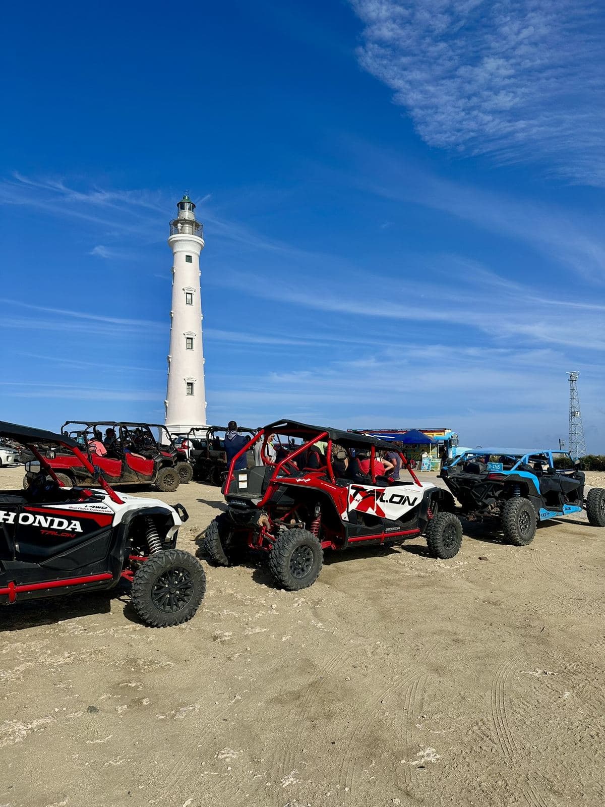 Red and blue side-by-side vehicles parked in front of the California Lighthouse
